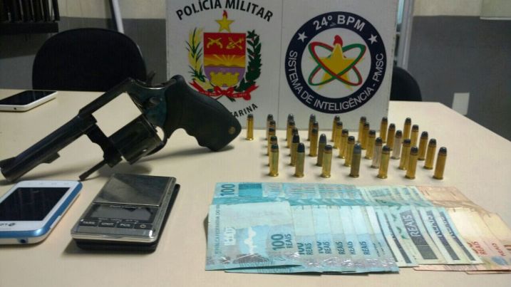 Revólver, munições e dinheiro que estavam com os acusados (Foto: PM)